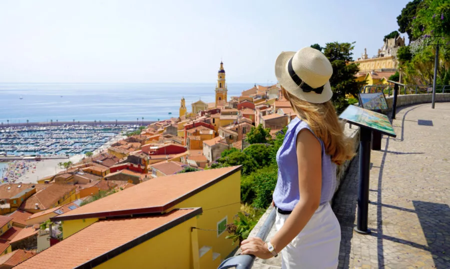 Férias na Riviera Francesa. Bela garota da moda apreciando vista da cidade de Menton na Riviera Francesa