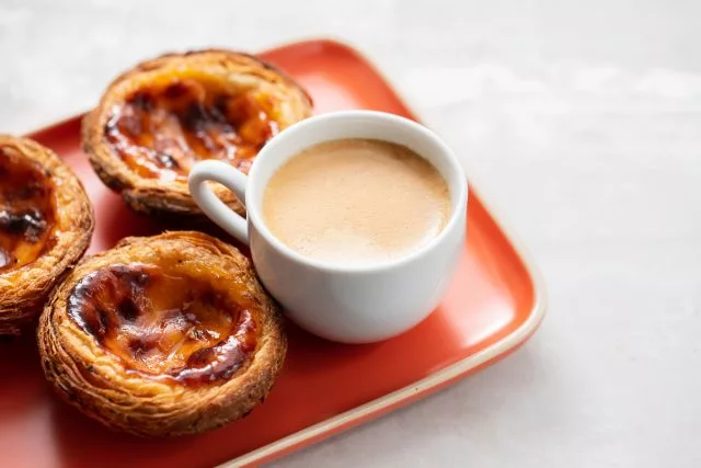 Bandeja cor laranja com três pasteis de belém portugueses - Culinária do continente europeu