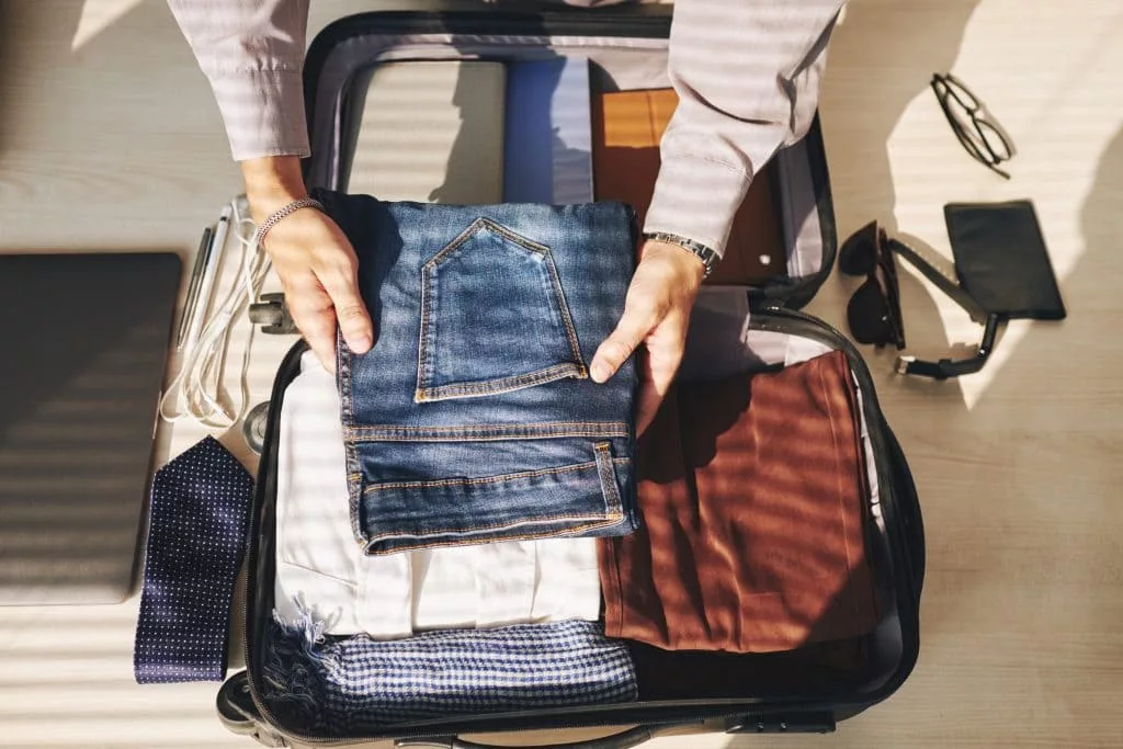 Homem de negocios arrumando sua mala de mao para viagem