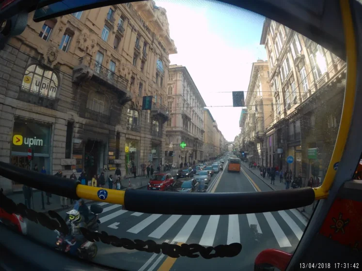 Vista do trânsito e dos edifícios de Gênova durante um trajeto de ônibus