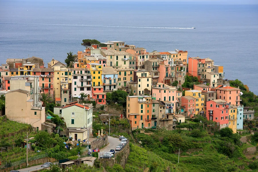Casas coloridas de Corniglia sobre a encosta, com o mar da Ligúria ao fundo.