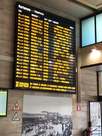 Interior da estação Venezia Santa Lucia com passageiros e sinalização de trens